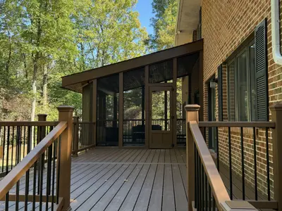 Composite deck with screened porch and brick home
