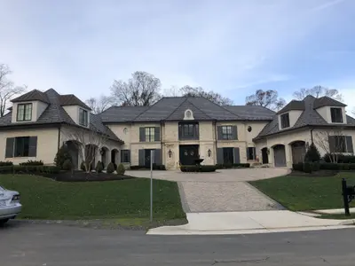 Large luxury stone home exterior with circular driveway