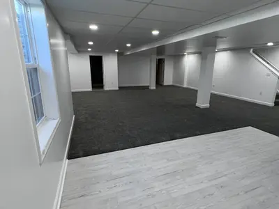 Finished basement transitioning between carpet and laminate flooring