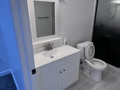 White bathroom vanity with mirror and toilet