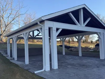 Outdoor pavilion with white posts and stamped concrete patio