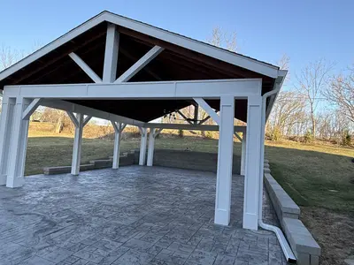 Outdoor pavilion with stamped concrete and stone retaining wall