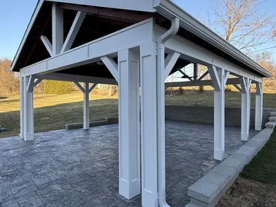 White pavilion with timber framed roof over patio