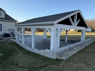 Pavilion next to two-story home with stone foundation