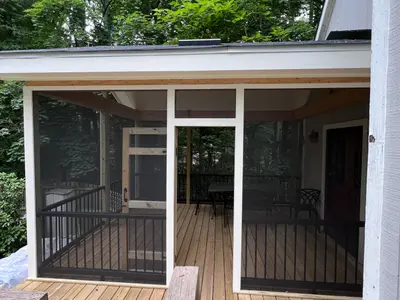 Screened porch with wood deck and metal railings
