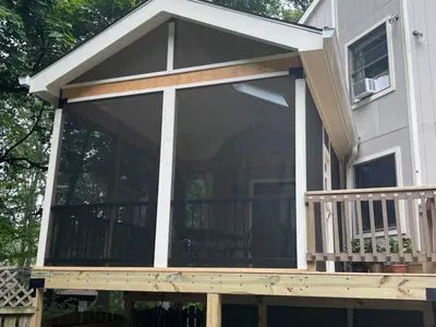 Two-story screened porch addition on gray house