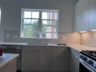 Modern kitchen with gray cabinets, white counters, gas range