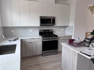modern kitchen with stainless gas range and gray cabinets