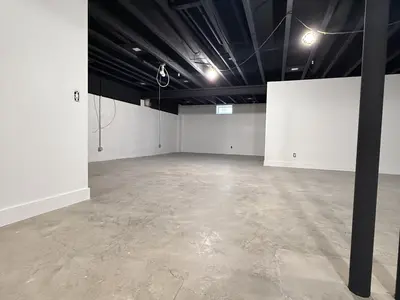 unfinished basement with black ceiling and concrete floor