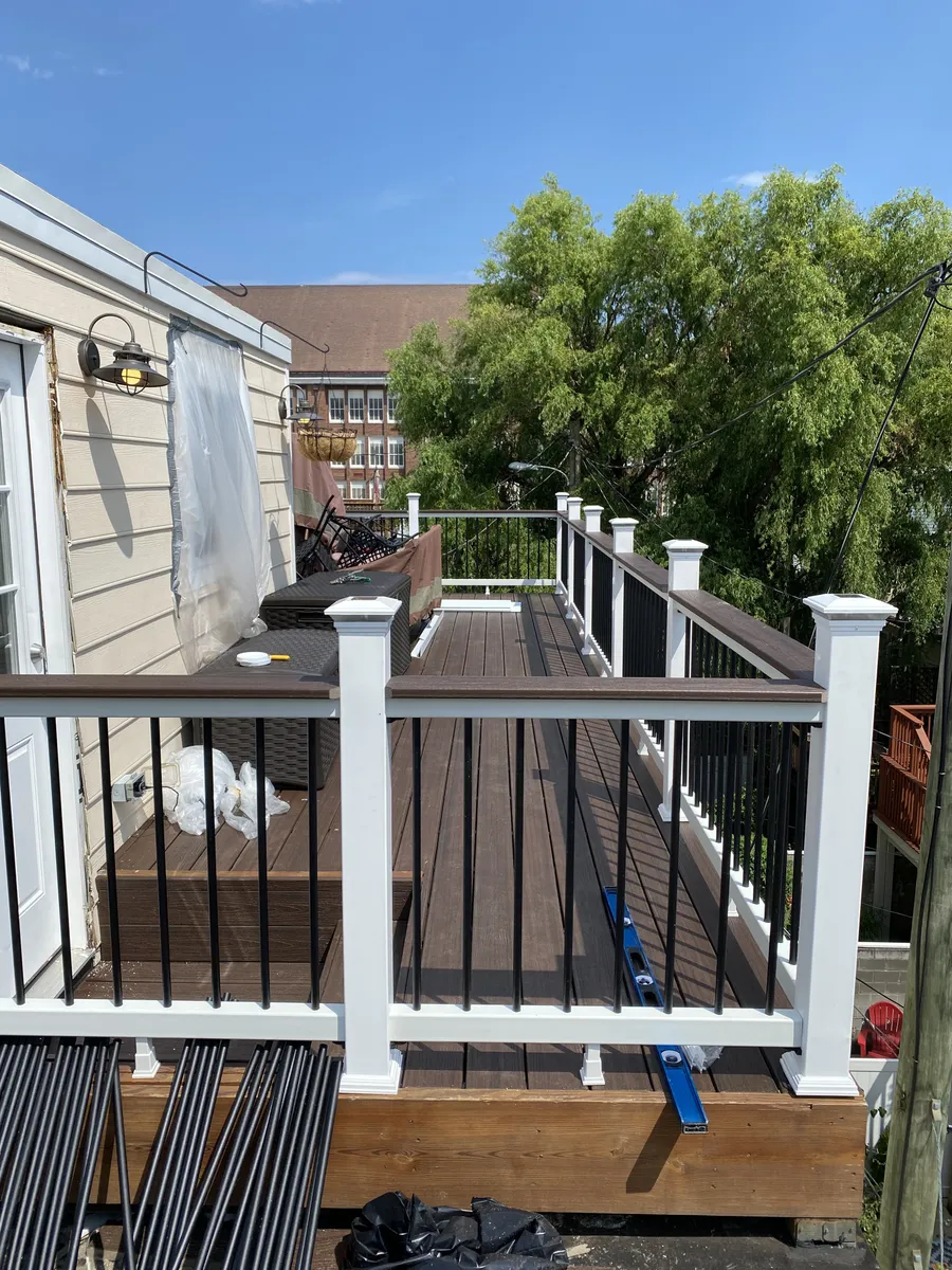 Rooftop composite deck with white railings and grill