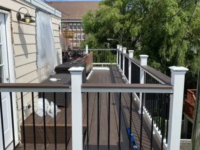 rooftop composite deck with white railings and grill