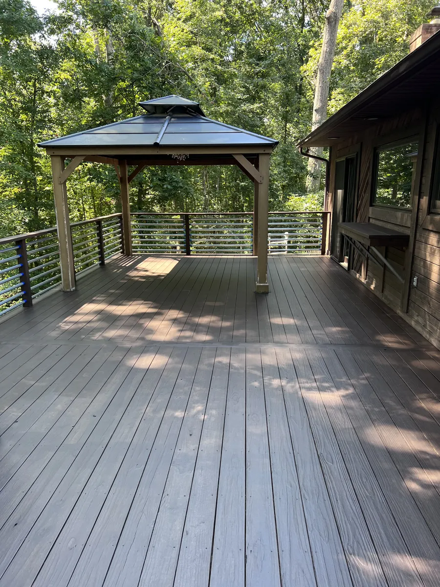 Composite deck with gazebo and cable railing in woods