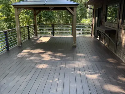 composite deck with gazebo and cable railing in woods