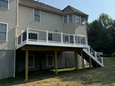 Elevated white-railing deck attached to vinyl-sided home
