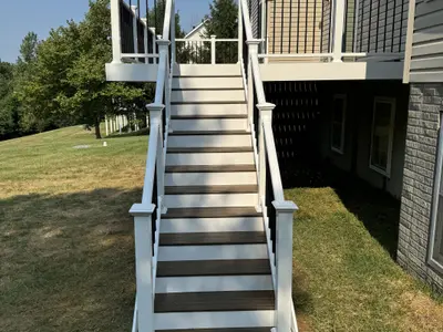 White-railed deck stairs leading down to lawn
