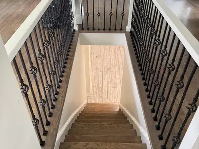 Hardwood staircase with wrought iron balusters down view