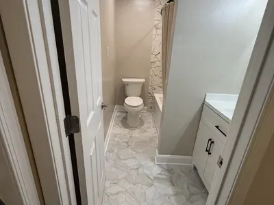 Small bathroom with toilet, vanity, marble flooring