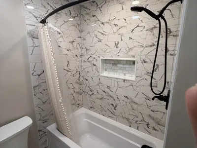 Marble shower tub with curtain, niche, black fixtures