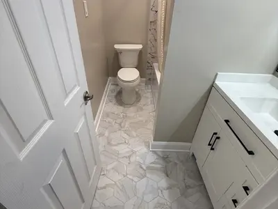Bathroom view with toilet, marble floor, white vanity