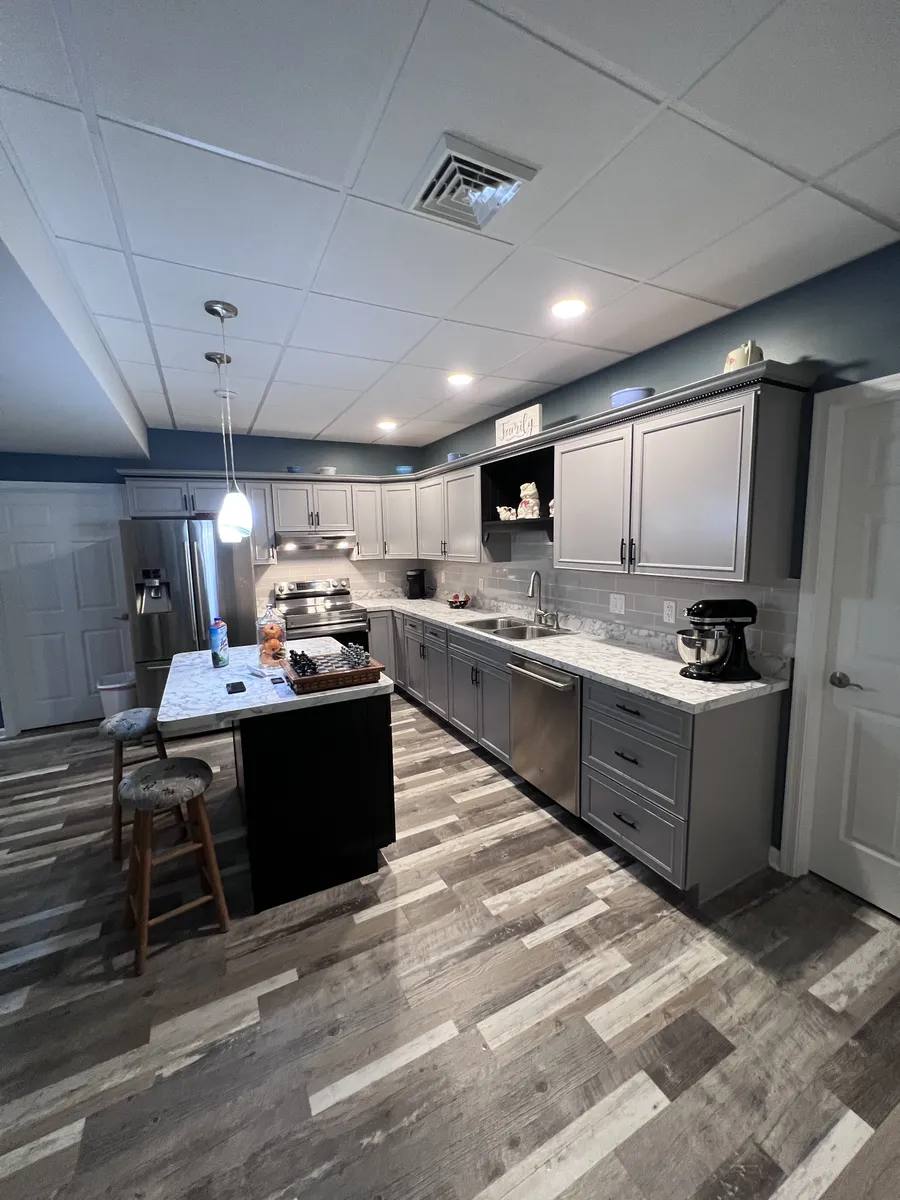 Basement kitchenette with gray cabinets and island