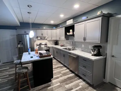 Basement kitchenette with gray cabinets and island