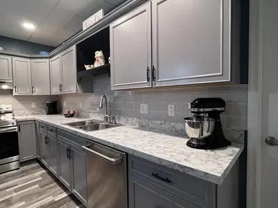 Basement kitchen counter with stand mixer and gray cabinets