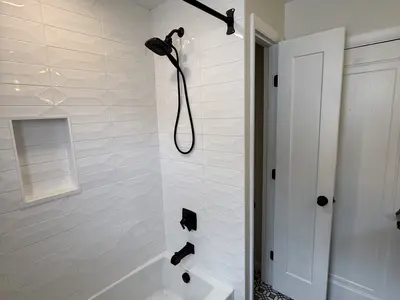 white subway tile shower with black fixtures
