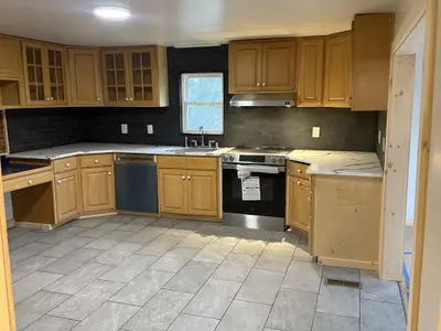 oak cabinet kitchen with tile floor and appliances