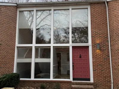 brick building with large window wall and red door