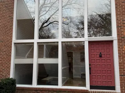 brick building with large window wall and red door