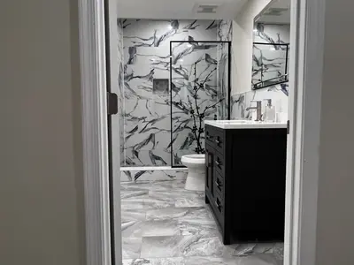 marble-look bathroom with black vanity and walk-in shower