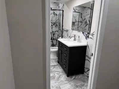 marble bathroom with dark vanity and mirror