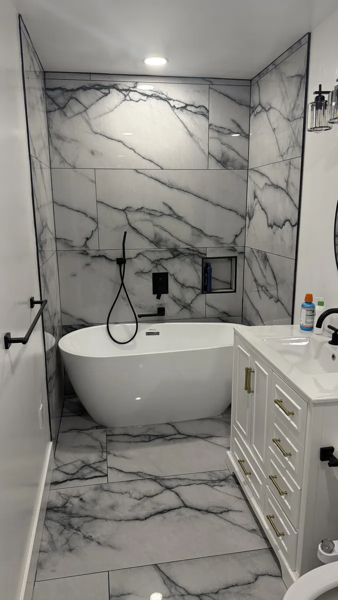 Spa-style bathroom with freestanding tub and marble walls