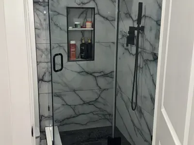 Glass marble shower enclosure with niche shelves