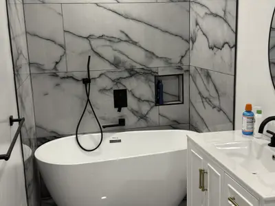 Freestanding tub with marble walls and white vanity