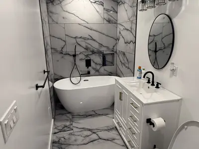 Bathroom with tub vanity round mirror marble tile