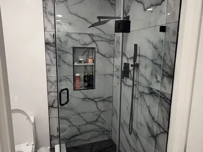 Walk-in marble shower glass enclosure with black fixtures
