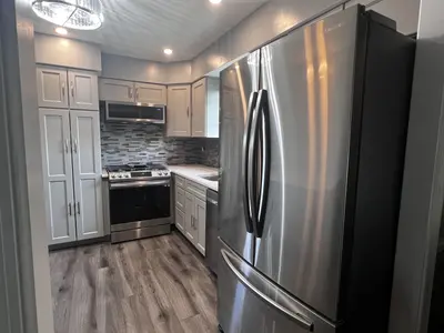 Gray cabinet kitchen with stainless steel refrigerator