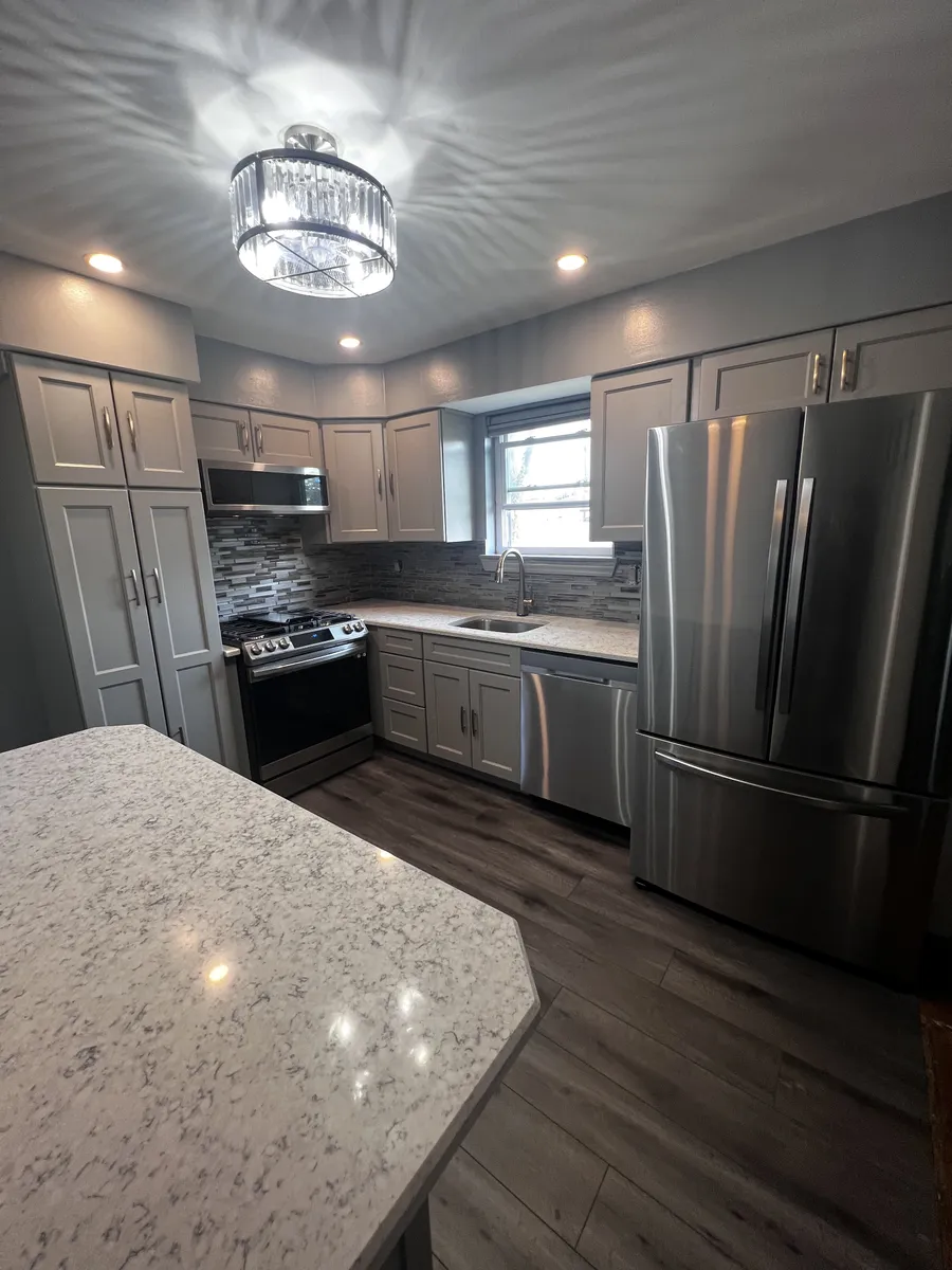 Custom kitchen with gray cabinetry and quartz island