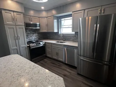 Gray kitchen with quartz island and stainless appliances