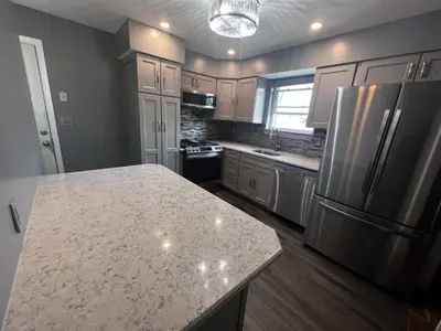 Kitchen island with light stone countertop gray cabinets