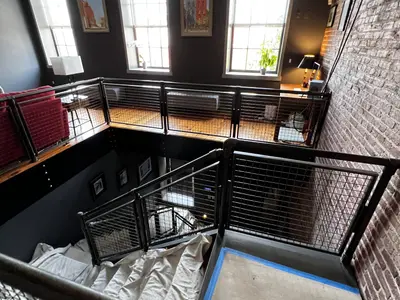 Loft staircase with metal railings brick wall windows
