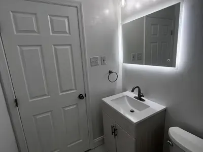 Small bathroom with vanity LED mirror white door