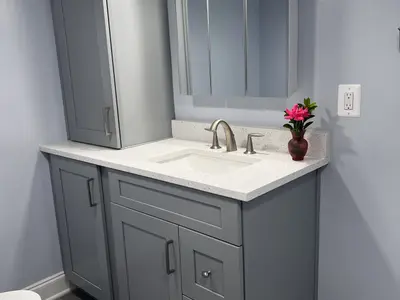 Gray vanity with white counter and flowers in vase