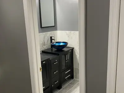 Black vanity with blue glass vessel sink