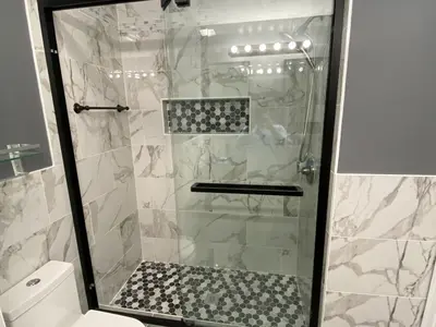 Walk-in shower with marble tile and mosaic accent