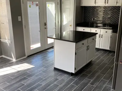 Kitchen island with black countertop and gray floor