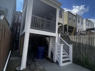 Exterior raised deck with white stairs between row houses