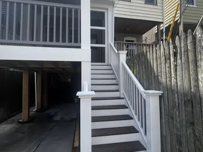 Exterior wooden stairs to deck with railings