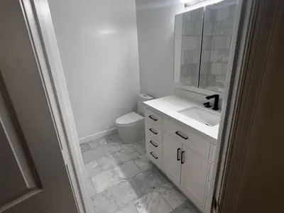 Compact bathroom with white vanity and toilet